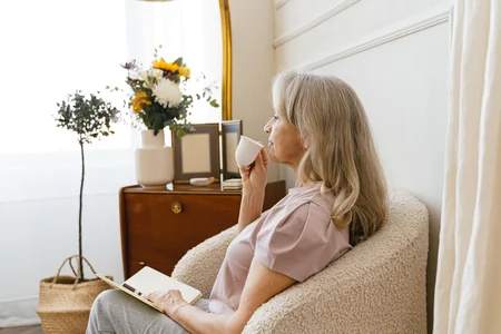 Woman drinking coffee by a window